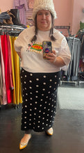 Load image into Gallery viewer, Additional full-body front view of a size 2X Victor Glemaud x Target black and white polka dot sweater maxi skirt styled with a white tee, white beanies, and yellow flats on a size 22/24 model.
