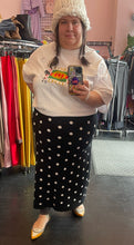 Load image into Gallery viewer, Additional full-body front view of a size 2X Victor Glemaud x Target black and white polka dot sweater maxi skirt styled with a white tee, white beanies, and yellow flats on a size 22/24 model.
