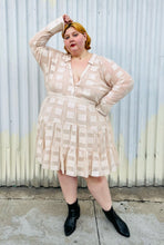 Load image into Gallery viewer, Additional full-body front view of a size 26 ASOS cream colored square pattern sheer mesh tiered button-up shirt dress with cream lining styled with black boots on a size 22/24 model. The photo is taken outside in natural lighting.
