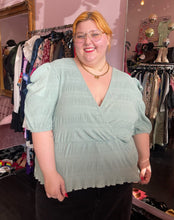 Load image into Gallery viewer, Front view of a size 24 ASOS sea foam green faux wrap textured babydoll blouse styled with black denim on a size 22/24 model.
