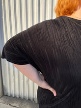 Load image into Gallery viewer, Close up view of the tight plisse pleats of a size 24 ASOS black plisse pleated tee on a size 22/24 model. The photo is taken outside in natural lighting.
