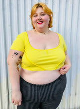 Load image into Gallery viewer, Front view of a size XXL Urban Outfitters size XXL (fits up to 20/22) lemon yellow exposed seam detail crop top with cap sleeves styled with black and white windowpane plaid pants on a size 22/24 model. The photo is taken outside in natural lighting.
