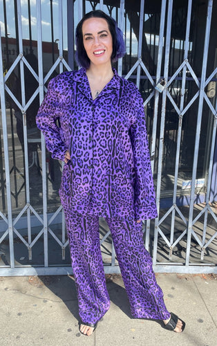 Full-body front view of a size 12/14 Dolce & Gabbana purple and black 100% silk leopard print pajama set from LIZZO'S CLOSET styled with black heels on a size 10 model.