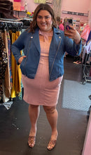 Load image into Gallery viewer, Full-body front view of a size 3 Fashion to Figure baby pink suede sheath dress with bust cut-outs styled under a denim moto jacket with brown heels on a size 18/20 model.
