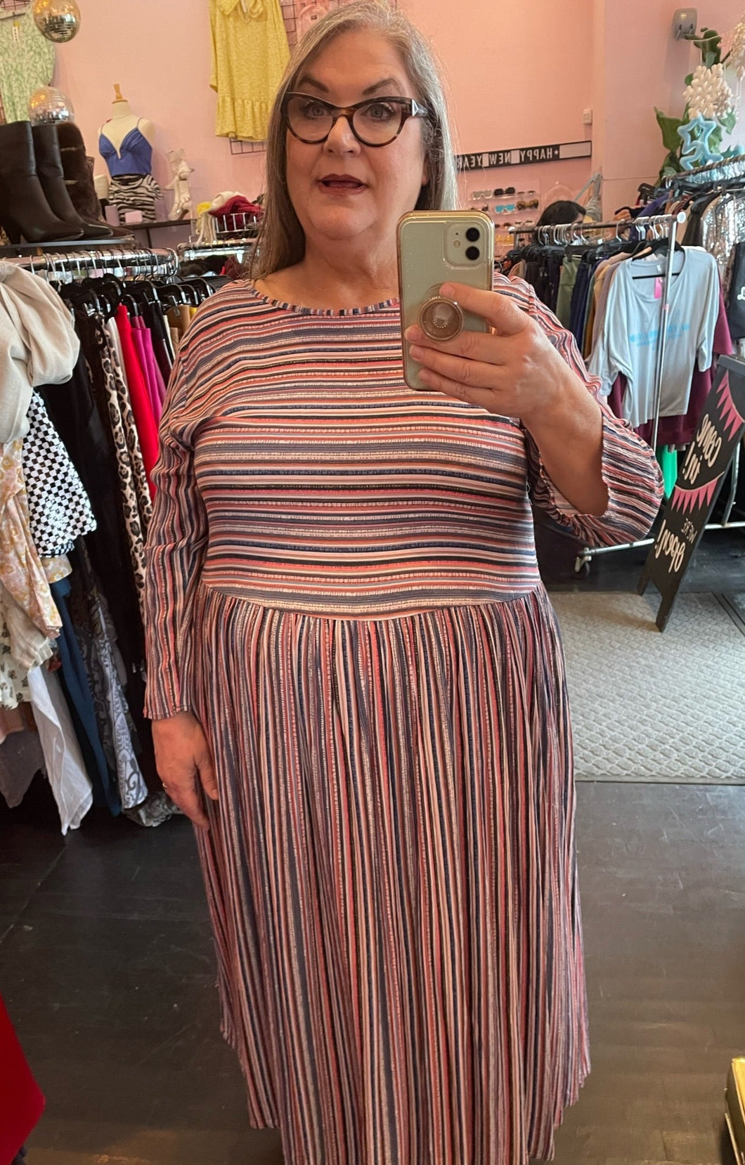 Full-body front view of a size 3/4X GOZZIP (UK brand) muted pink, blue, orange, and white horizontal and vertical striped long sleeve maxi dress on a size 20/22 model.