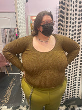 Load image into Gallery viewer, Front view of a size XL (fits up to size 24) GANNI deep gold metallic ribbed knit sweater styled with olive green trousers on a size 24 model. The photo is taken inside in overhead lighting.
