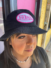 Load image into Gallery viewer, Side-long close up on the black FAT BITCH bucket hat, a black hat with a white and pink embroidered patch that reads &quot;Fat Bitch.&quot;
