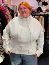 Load image into Gallery viewer, Front view of a size 4X Fabletics pastel blue darted and flared hem hoodie styled over a pair of lightwash jeans on a size 22/24 model.
