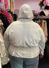 Load image into Gallery viewer, Back view of a size 4X Fabletics pastel blue darted and flared hem hoodie styled with the hood up over a pair of lightwash jeans on a size 22/24 model.
