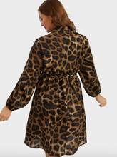 Load image into Gallery viewer, Back view of a size 12 Bloomchic brown and black leopard print a-line midi dress with long sleeves, bussy bow, and tie delt on a size 14 model.
