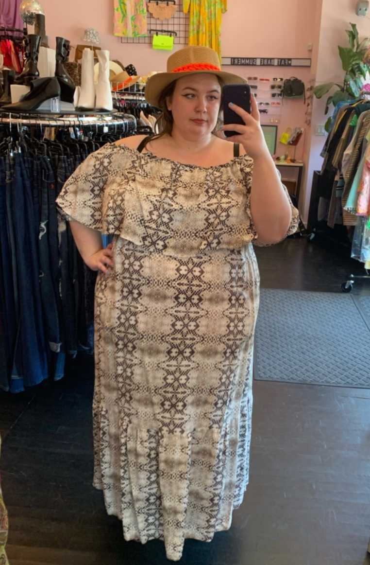 Full-body front view of a size 22 Eloquii brown and cream off-the-shoulder foldover maxi dress styled with a brown and orange wicker boater hat on a size 24 model.