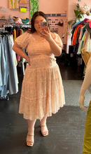 Load image into Gallery viewer, Additional full-body front view of a size L Ivy City blush pink tiered midi dress with mini ruffles, puff sleeves, and a smocked bust styled with tan heels on a size 14/16 model.
