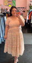 Load image into Gallery viewer, Slightly closer front view of a size L Ivy City blush pink tiered midi dress with mini ruffles, puff sleeves, and a smocked bust styled with tan heels on a size 14/16 model.
