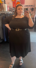 Load image into Gallery viewer, Full-body front view of a size 22/24 Beauticurve x Lane Bryant collab black off-the-shoulder midi dress styled with a black and gold snake belt and a pearl headband on a size 24 model.
