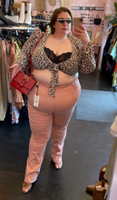 Load image into Gallery viewer, Full-body front view of a pair of size 24 Fashion to Figure peach-pink straight leg denim styled with a leopard print tie-front top, a red handbag, and snakeprint heels on a size 24 model.
