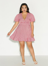 Load image into Gallery viewer, Full-body front view of a Bloomchic red and white ditsy floral mini dress with a ruffled hem.
