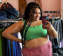 Load image into Gallery viewer, Close up view of a size 18 ASOS kelly green crop top with gathered straps styled with pink and maroon gingham plaid trousers on a size 18/20 model.
