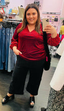 Load image into Gallery viewer, Full-body front view of a size 3X JM Collection red and black velvet animal print v-neck blouse styled with black pants on a size 18/20 model.
