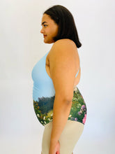 Load image into Gallery viewer, Side view of a size 2X WRAY one piece swimsuit with a ruched detail in the middle on a size 18/20 model.
